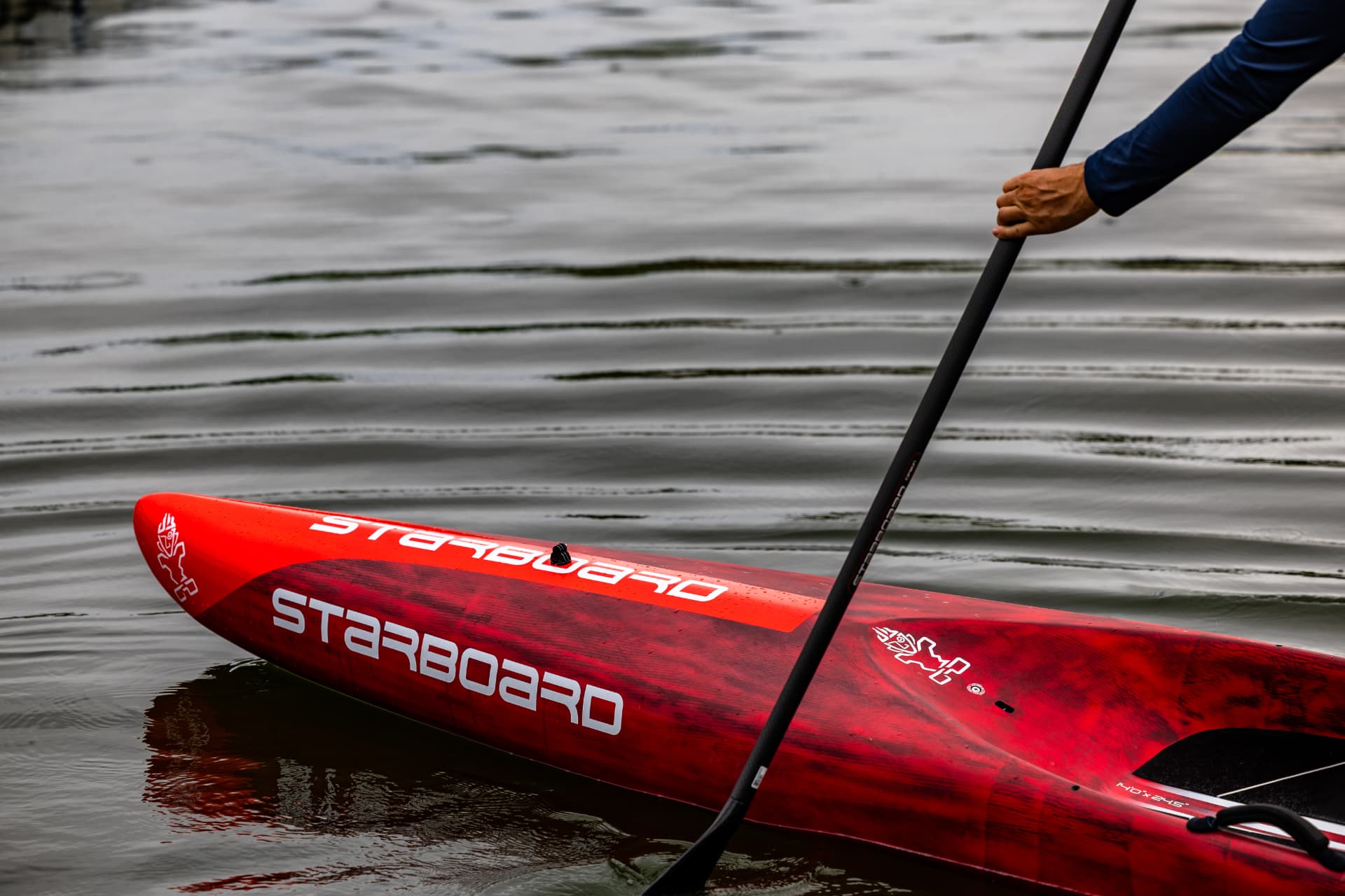 Close view of a red Starboard paddleboard on the lake
