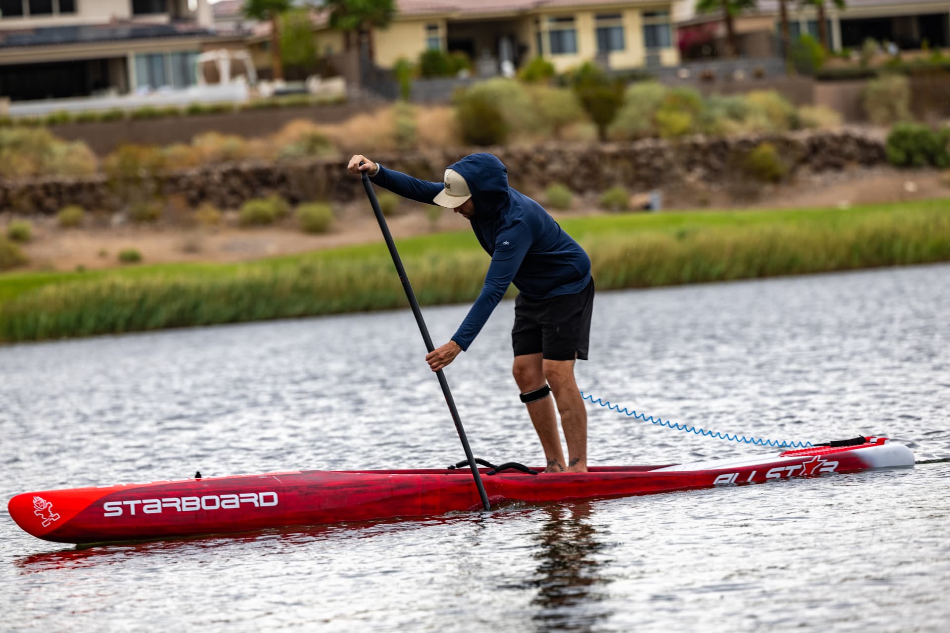 Paddler training on a red Starboard race board at Lake Las Vegas